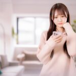 スマホでマッチングアプリを見ながら悩む女性