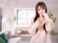 スマホでマッチングアプリを見ながら悩む女性